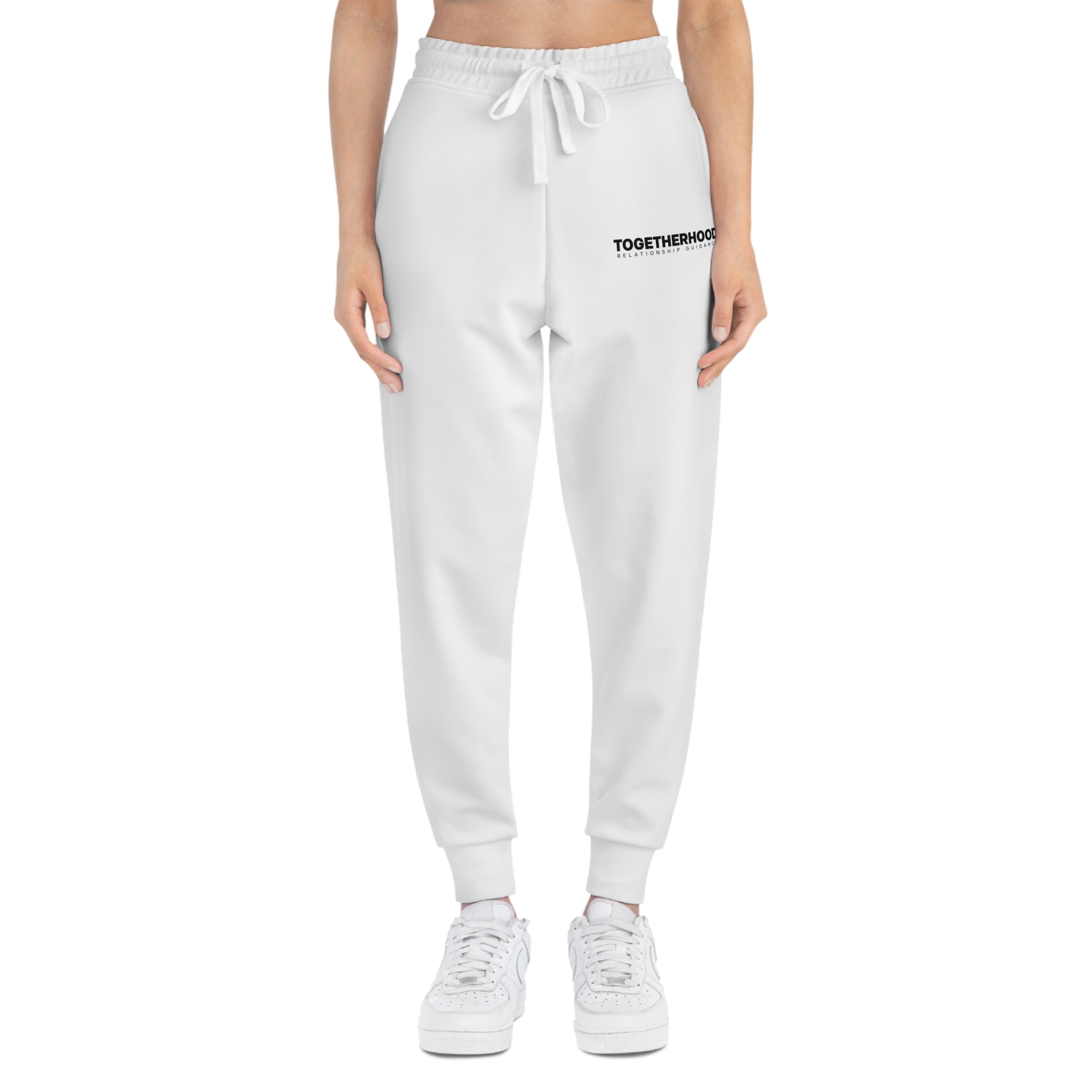 White joggers on woman with black togetherhood logo in front.